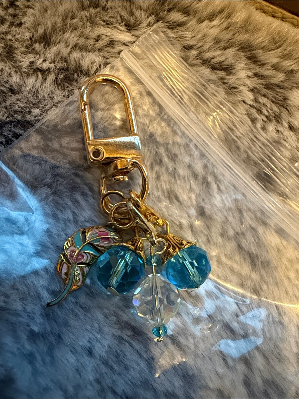 Gold & blue bag charm with Blue and Clear Beads & gold & blue feather charm.